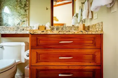 a bathroom with a wooden sink and a toilet at Stylish Split-Level Condo with a Shaded Terrace, Direct Beach Access, and Resort-Style Community Amenities in Playa Flamingo