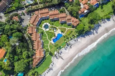 an aerial view of a resort on the beach at Stylish Split-Level Condo with a Shaded Terrace, Direct Beach Access, and Resort-Style Community Amenities in Playa Flamingo
