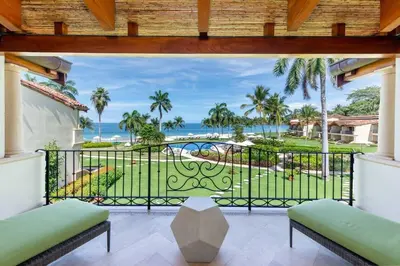 a balcony with a view of the ocean at Modern Oceanfront Condo with a Chic Coastal Design, Resort-Style Amenities, and Direct Beach Access in Playa Flamingo