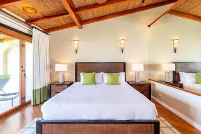 a bedroom with a large bed with green pillows at Modern Oceanfront Condo with a Chic Coastal Design, Resort-Style Amenities, and Direct Beach Access in Playa Flamingo