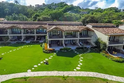an aerial view of a house with a large yard at Modern Oceanfront Condo with a Chic Coastal Design, Resort-Style Amenities, and Direct Beach Access in Playa Flamingo