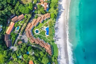 an aerial view of a house on the beach at Modern Oceanfront Condo with a Chic Coastal Design, Resort-Style Amenities, and Direct Beach Access in Playa Flamingo
