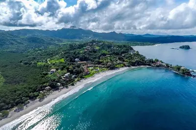 an aerial view of a beach and the ocean at Modern Oceanfront Condo with a Chic Coastal Design, Resort-Style Amenities, and Direct Beach Access in Playa Flamingo