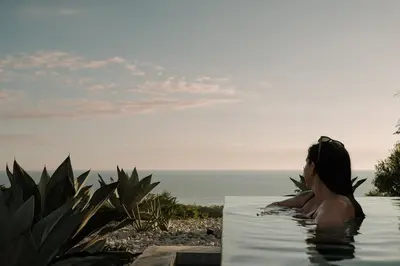 a woman sitting in a bath tub looking out at the ocean at Sky House Santa Teresa - Adults only in Santa Teresa Beach