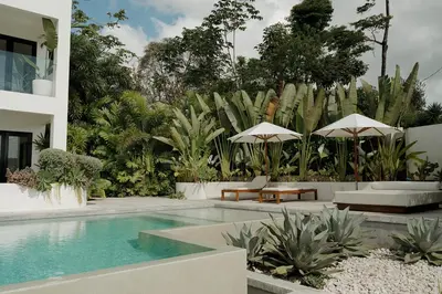 a house with a swimming pool with chairs and umbrellas at Sky House Santa Teresa - Adults only in Santa Teresa Beach