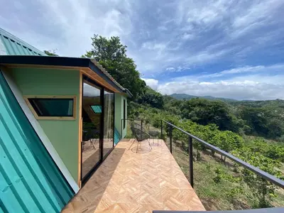 a balcony of a house with chairs on it at Tityra Lodge in Monteverde Costa Rica