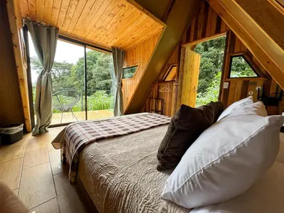 a bedroom with a bed in a room with a window at Tityra Lodge in Monteverde Costa Rica