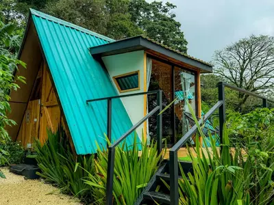 a tiny house with a blue roof at Tityra Lodge in Monteverde Costa Rica