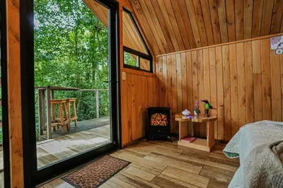 a room with a bed and a fireplace in a cabin at Tityra Lodge in Monteverde Costa Rica