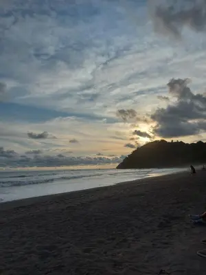 a group of people walking on the beach at Centro Vacacional Bancosta in Jacó