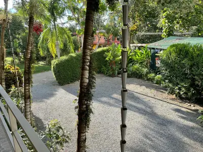 a palm tree standing next to a white fence at Hotel LUZ de LUNA Bahía Ballena in Uvita