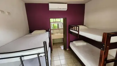 a room with three bunk beds and a window at Hotel LUZ de LUNA Bahía Ballena in Uvita