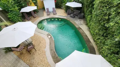 an overhead view of a swimming pool with chairs and umbrellas at Hotel LUZ de LUNA Bahía Ballena in Uvita