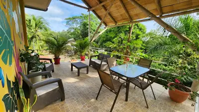a patio with a table and chairs and plants at Hotel LUZ de LUNA Bahía Ballena in Uvita