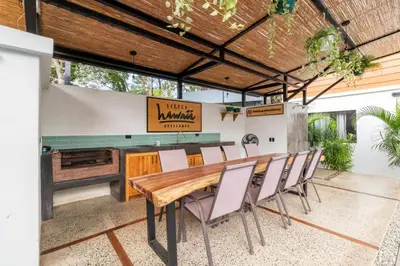 a dining room with a wooden table and chairs at Little Hawaii Avellanas in Playa Avellana
