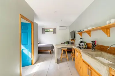 a kitchen with a sink and a table in a room at Little Hawaii Avellanas in Playa Avellana
