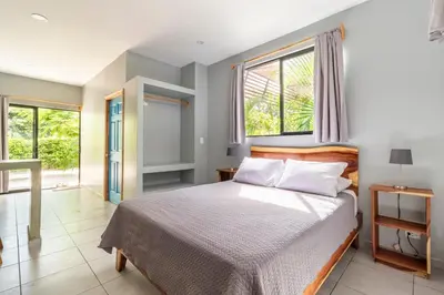 a bedroom with a bed and a window at Little Hawaii Avellanas in Playa Avellana
