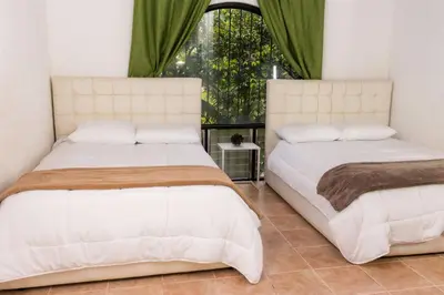 two beds in a bedroom with a window at Hotel Casona del Valle in Potrerillos
