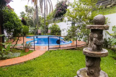 a swimming pool in a yard with a statue at Hotel Casona del Valle in Potrerillos
