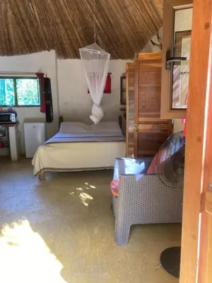 a bedroom with a bed and a couch in a room at Mundo Milo Eco Lodge in Playa Junquillal