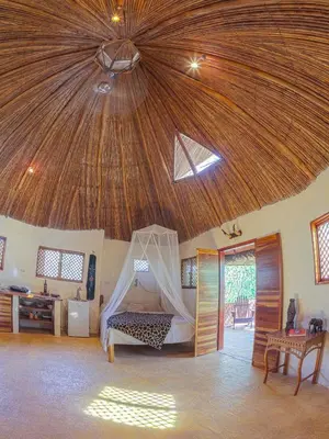 a bedroom with a bed with a wooden ceiling at Mundo Milo Eco Lodge in Playa Junquillal