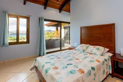 a bedroom with a bed and a large window at Modern, Immaculate Unit in Flamingo with Spectacular Ocean Views in Playa Flamingo