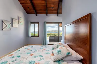 a bedroom with a large bed with a wooden headboard at Modern, Immaculate Unit in Flamingo with Spectacular Ocean Views in Playa Flamingo