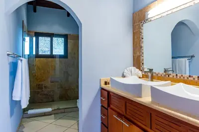 a bathroom with two sinks and a shower at Modern, Immaculate Unit in Flamingo with Spectacular Ocean Views in Playa Flamingo