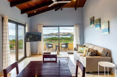 a living room with a couch and a table at Modern, Immaculate Unit in Flamingo with Spectacular Ocean Views in Playa Flamingo
