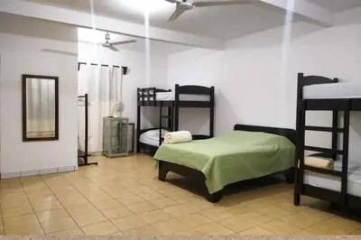a room with three bunk beds in a room at Restaurante y cabinas Sudy in Carara