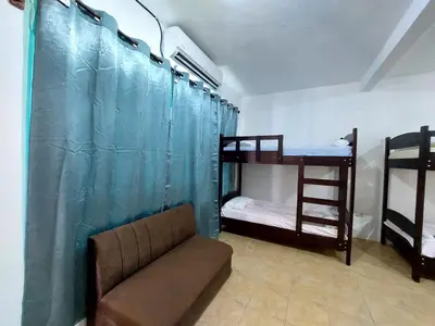 a living room with a couch and bunk beds at Restaurante y cabinas Sudy in Carara