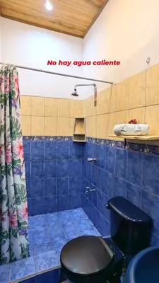 a blue tiled bathroom with a toilet in a room at Casa Victoria in Puntarenas