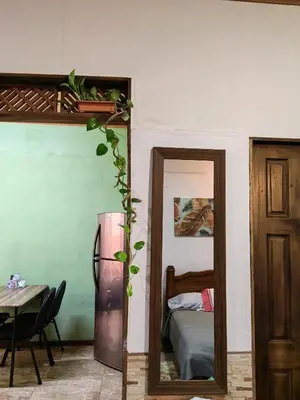 a room with a refrigerator and a table and a bed at Casa Victoria in Puntarenas