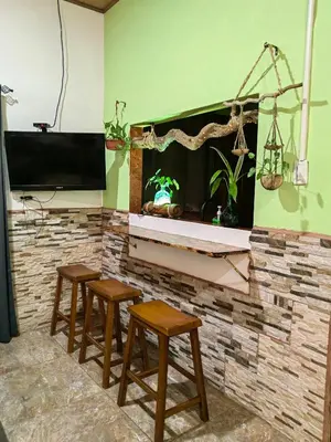a group of stools in a room with a fireplace at Casa Victoria in Puntarenas