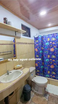 a bathroom with a toilet and a sink and a shower curtain at Casa Victoria in Puntarenas
