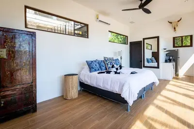 a bedroom with a bed and a ceiling fan at Stunning Home with Brand-New Guesthouse and Oceanview Terrace with Private Swimming Pool & Hot Tub in Playa Flamingo