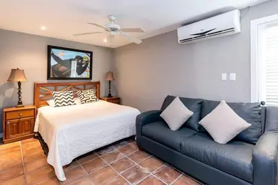 a bedroom with a bed and a couch at Stunning Home with Brand-New Guesthouse and Oceanview Terrace with Private Swimming Pool & Hot Tub in Playa Flamingo