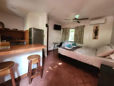a bedroom with a bed and a kitchen with a counter at Villas Pura Vibra in Potrero