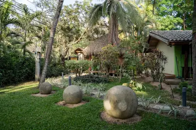 a yard with stone spheres in front of a house at Villas Pura Vibra in Potrero