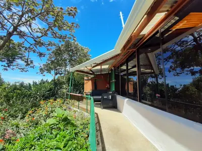 a house with a view of a garden at Mountain view Monteverde, Cecropia Paradise in Monteverde Costa Rica