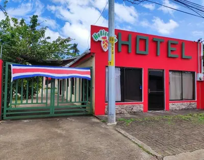 a red building with a hotel sign on it at Hotel Heliconia Los Chiles in Los Chiles