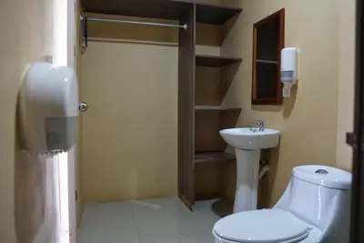 a bathroom with a toilet and a sink at Hotel Heliconia Los Chiles in Los Chiles