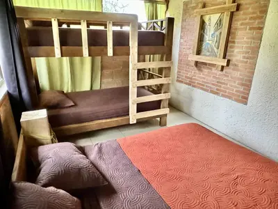 a small room with a bunk bed and a couch at Casa Lajas - Casa 1 - Hospedaje, Granja y Turismo Rural in Turrialba