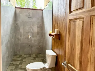 a bathroom with a toilet and a shower at Casa Lajas - Casa 1 - Hospedaje, Granja y Turismo Rural in Turrialba