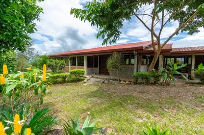 a house with a garden in front of it at Casa Lajas - Casa 1 - Hospedaje, Granja y Turismo Rural in Turrialba