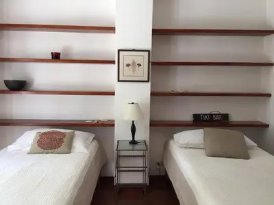 two beds in a room with wooden shelves at Montelaguna Boutique Hotel in Sámara