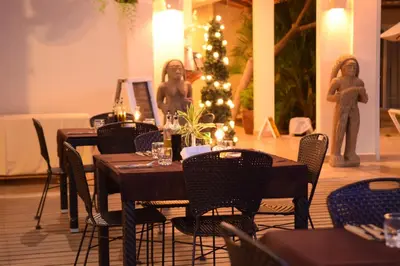 a dining room with tables and chairs and a christmas tree at Montelaguna Boutique Hotel in Sámara