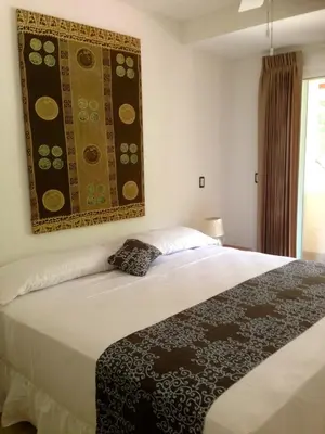 a bedroom with a bed with a rug on the wall at Montelaguna Boutique Hotel in Sámara