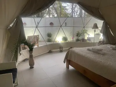 a bedroom with a bed and a large window at Amaj Eco Lodge in Sámara