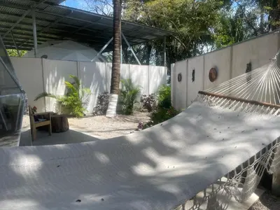 a hammock in a yard with a fence at Amaj Eco Lodge in Sámara